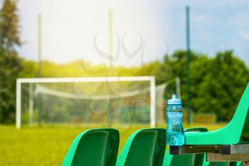 Sport bottle of fresh water on the chairs of school stadium