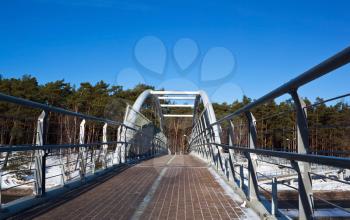 Walking bridge over the road near forest in winter