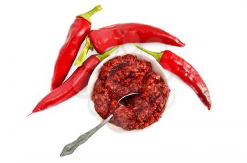 Royalty Free Clipart Image of a Cup of Chopped Hot Peppers With Peppers Beside It