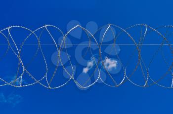 Barbed wire on a background of blue sky