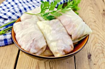 Prepared stuffed cabbage with minced, parsley in a dish, napkin on the background of wooden boards