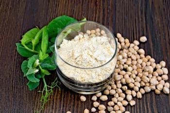 Flour chickpeas in glassful, pods of green beans and chick-pea on a wooden board