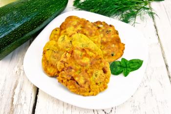 Indian chick-pea flour flatbreads with zucchini and fresh herbs, basil in a plate on a wooden boards background