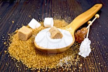 Sugar is brown and white in cubes, granulated in a spoon and crystal on a stick against the background of a wooden table