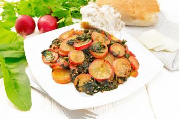 Radish stewed with spinach and spices in a plate, cheese and bread, towel against white wooden board background