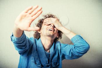 Innocent Man showing stop. one hand showing the stop, the other closes his eyes