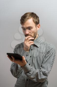 young man reading interesnting stuff on his electronic tablet pad
