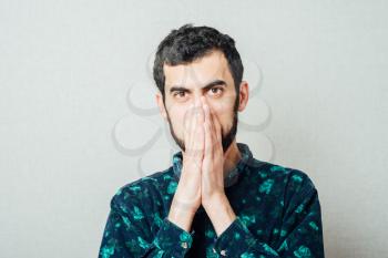 Closeup portrait of young man thinking daydreaming deeply about something with chin on hand fist looking downwards. Emotion facial expressions feelings