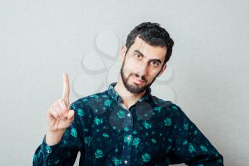 Young male having idea with index finger pointing up concept. Studio portrait over retro vignette background.