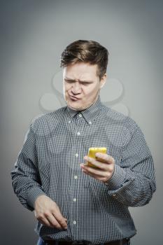 A confused young man looking at mobile phone