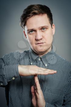 Portrait of young man gesturing time out sign
