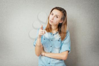 Closeup portrait shocked terrified business woman looking surprised full disbelief saw something pointing finger at camera  grey wall background. Negative emotion facial expression reaction