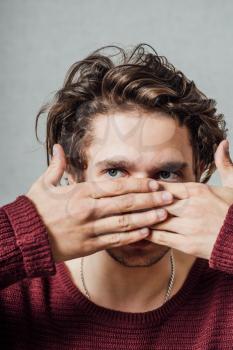 Young man covering his mouth with hands