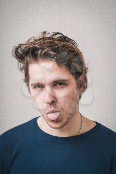 portrait of a young man showing his tongue