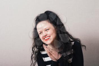 Woman laughing covering his face. Gray background