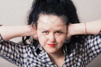  young woman covering her ears with her hands