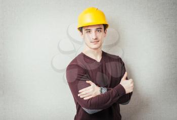 Handsome young man with protective helmet on his head and arms crossed