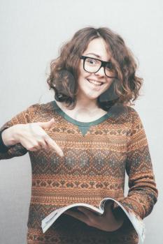 girl with glasses points his finger to the journal