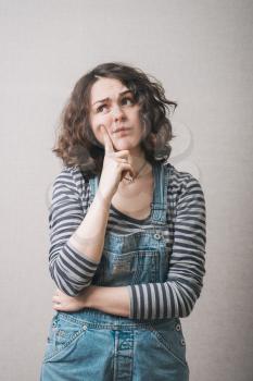 woman remembers something, dressed in overalls