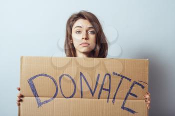 young woman showing board with text: Donate