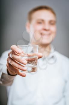 handsome man in white shirt with glass of water