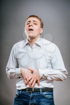 Portrait of young businessman suffering from stomach pain