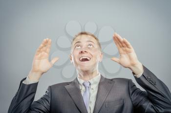Unsure businessman shrugs his shoulders and throws his hands in the air
