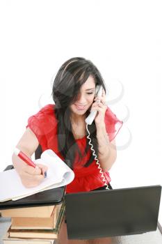 Smiling young business woman on phone taking notes in office 
