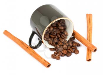 Royalty Free Photo of a Black Coffee Cup with Coffee Beans Spilling out and Sticks of Cinnamon