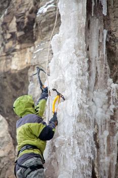 Man with ice axes climbing on icefall
