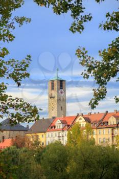 City tower with clock and old buildings, trees in Bamberg, Germany
