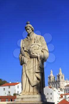 Statue of Saint Vicente de Fora in Lisbon and house roofs, Portugal
