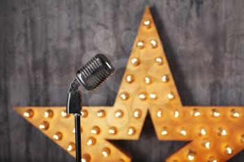 Vintage microphone in studio with star on background
