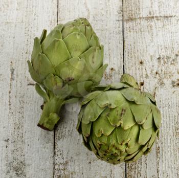Raw Artichokes On Wooden Background