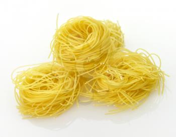 Raw pasta nests on a white background