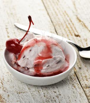 Vanilla And Cherry Ice Cream On A Wooden Table