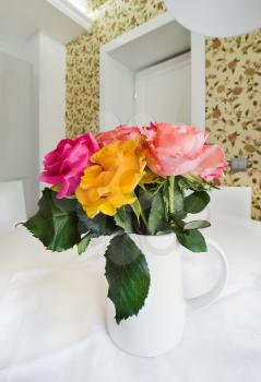 Colored roses in white vase