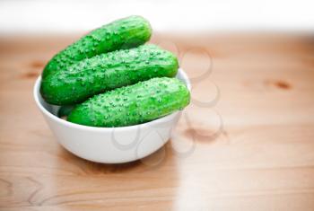 Fresh green pickling cucumbers in bowl 