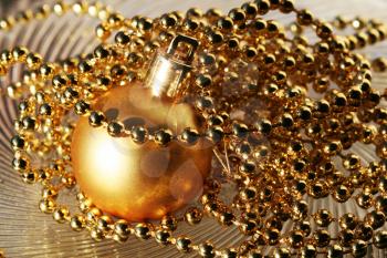 Royalty Free Photo of a Golden Christmas Ball and Beads