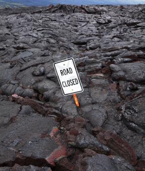 Royalty Free Photo of a Road Sign Buried in Lava
