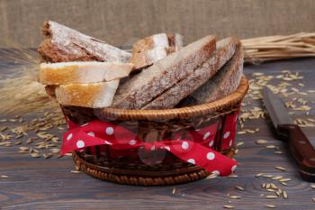 Sliced bread in a basket on wooden background