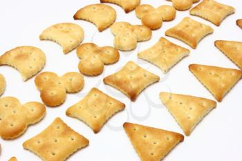 Salty crackers of the various geometrical form lie on a white background