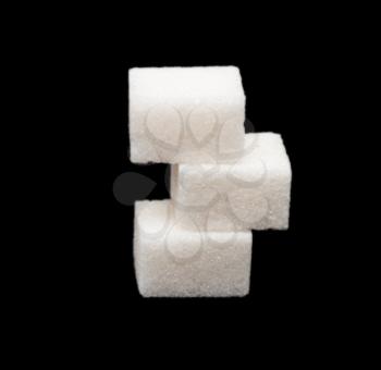 three lumps of sugar on a black background