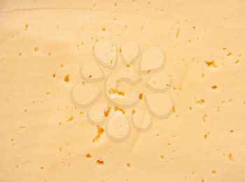 Background of fresh yellow Swiss cheese with holes 