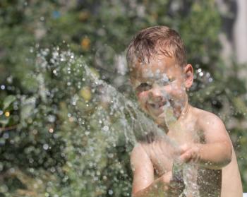 boy squirting water from a hose