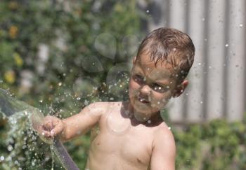 boy squirting water from a hose