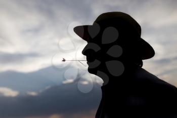 silhouette of a man with a hat on sunset background