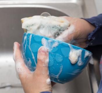 boy washing dishes in the kitchen