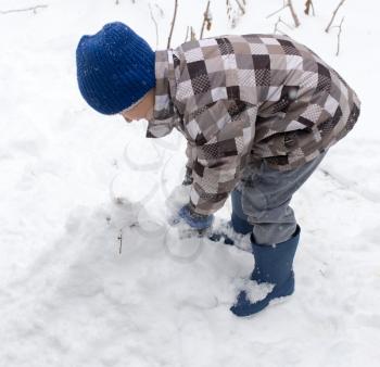 Boy playing with snow in winter