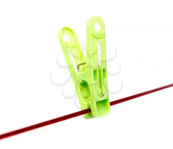Green clothespin on a rope on a white background .